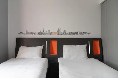 two beds sitting next to each other in a room at easyHotel Ipswich in Ipswich