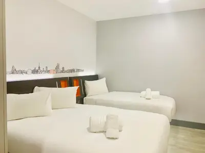 two beds in a hotel room with white walls at easyHotel Ipswich in Ipswich