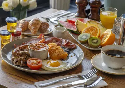 a table with plates of breakfast food on it at St Nicholas Hotel Colchester in Colchester