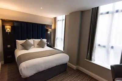 a bedroom with a bed and a large window at St Nicholas Hotel Colchester in Colchester