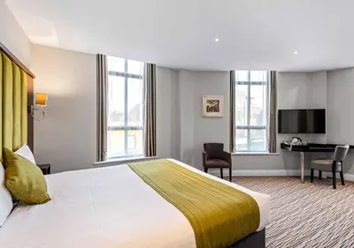 a hotel room with a bed and a desk at St Nicholas Hotel Colchester in Colchester