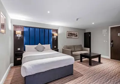 a hotel room with a bed and a couch at St Nicholas Hotel Colchester in Colchester