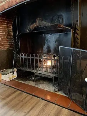 a brick fireplace with a fire in it at Swan Hotel in Harleston