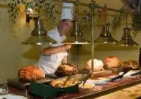 a chef preparing food on a counter in a kitchen at Swan Hotel in Harleston