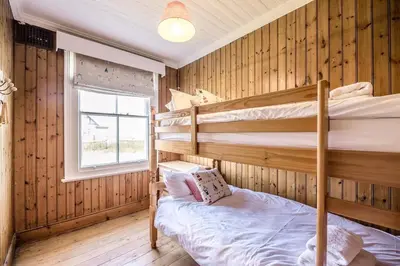 a bedroom with two bunk beds and a window at Fairhaven, Thorpeness in Thorpeness