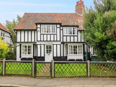 a black and white house with a fence at 7 Whinlands in Thorpeness