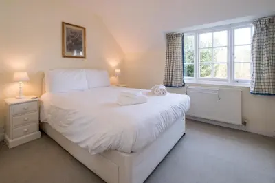 a bedroom with a large white bed and a window at 7 Whinlands in Thorpeness