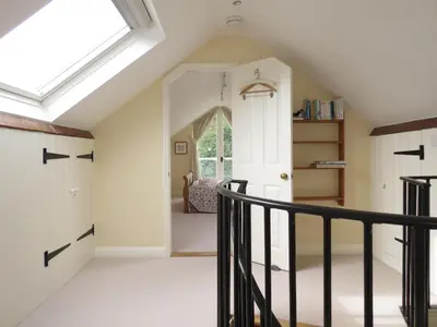 an attic hallway with a skylight and a staircase at Crossing Cottage, Thorpeness in Thorpeness