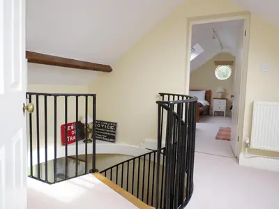 a hallway with a staircase in a house at Crossing Cottage, Thorpeness in Thorpeness