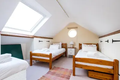 a attic bedroom with two beds and a skylight at Crossing Cottage, Thorpeness in Thorpeness