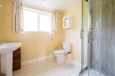 a bathroom with a toilet and a sink and a shower at Crossing Cottage, Thorpeness in Thorpeness