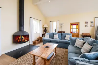 a living room with a couch and a fireplace at Crossing Cottage, Thorpeness in Thorpeness