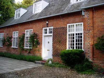 a red brick house with a white door and windows at The Courtyard in Newmarket