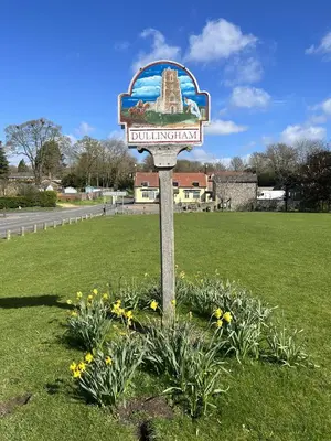a sign in the middle of a field with flowers at The Courtyard in Newmarket