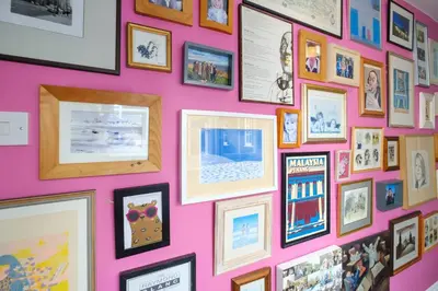 a wall full of pictures on a pink wall at 2 Ogilvie Lodge in Thorpeness