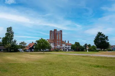 a large building with a grass field in front of it at 2 Ogilvie Lodge in Thorpeness