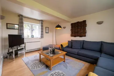 a living room with a blue couch and a table at 2 Ogilvie Lodge in Thorpeness
