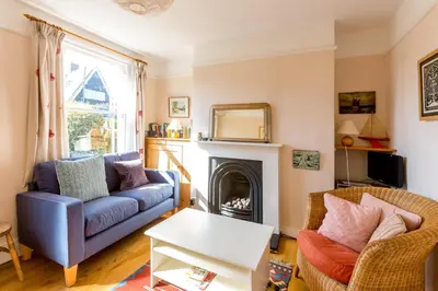 a living room with a couch and a fireplace at 5 Coastguard Cottages in Aldeburgh