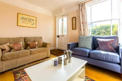 a living room with two couches and a table at 5 Coastguard Cottages in Aldeburgh
