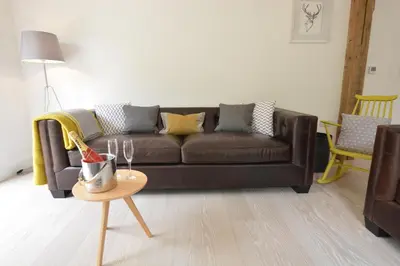 a living room with a brown couch and a table at Red Poll Barn in Spexhall