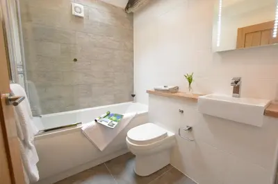 a white bathroom with a toilet and a sink at Red Poll Barn in Spexhall