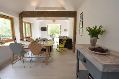 a kitchen and dining room with a table and chairs at Red Poll Barn in Spexhall