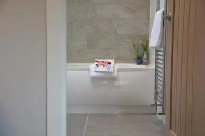 a bathroom with a bath tub with a box on it at Milk Parlour in Spexhall