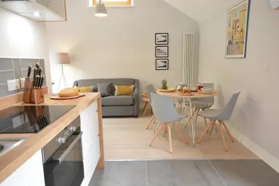 a kitchen and living room with a table and chairs at Milk Parlour in Spexhall
