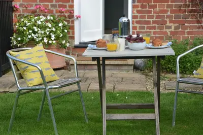 a table with food on it with two chairs at Rookyards in Spexhall