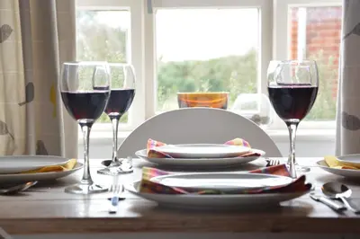 a table with two glasses of red wine on it at Rookyards in Spexhall
