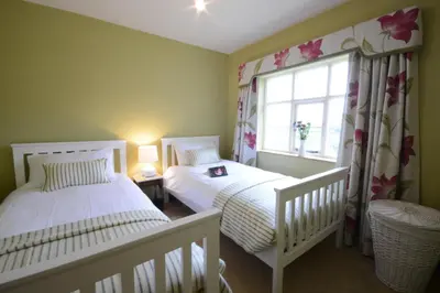 two beds in a small room with a window at Rookyards in Spexhall