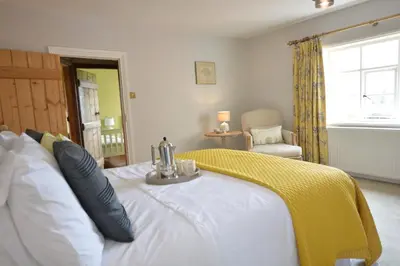 a bedroom with a bed with a yellow blanket on it at Rookyards in Spexhall