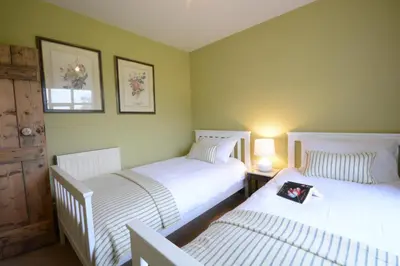 two twin beds in a room with two lamps at Rookyards in Spexhall