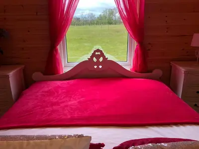 a bedroom with a red bed with a window at Thompson Hall Retreat in Thompson