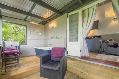 a bathroom with a chair and a sink and a tub at Thompson Hall Retreat in Thompson
