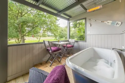 a bathroom with a tub and a table with chairs at Thompson Hall Retreat in Thompson