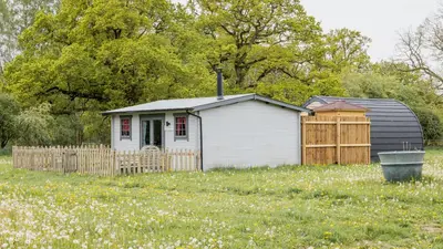 a small white house in a field of flowers at Thompson Hall Retreat in Thompson