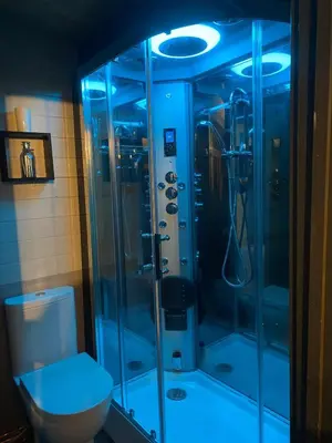 a bathroom with a glass shower with a toilet at Thompson Hall Retreat in Thompson