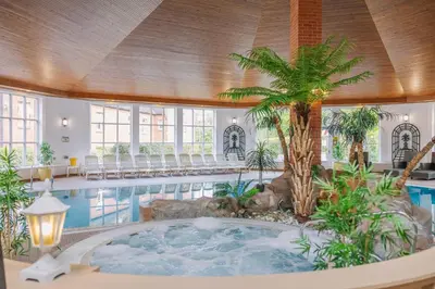 a large indoor pool with a hot tub in the middle of a building at Muthu Belstead Brook Hotel in Ipswich