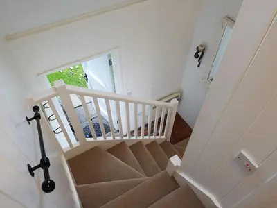 a staircase with white railings and a white stair case at Wellrose Barn in Hertford