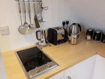 a kitchen counter with a sink and utensils at Wellrose Barn in Hertford