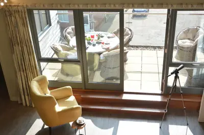 a room with a table and a chair and a camera at King George Penthouse in Aldeburgh