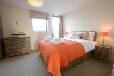 a bedroom with a bed with two towels on it at King George Penthouse in Aldeburgh