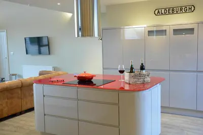 a kitchen with a counter with wine bottles on it at King George Penthouse in Aldeburgh