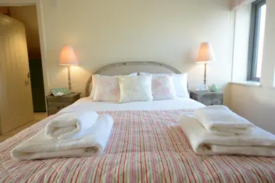 a bedroom with a bed with towels on it at King George Penthouse in Aldeburgh