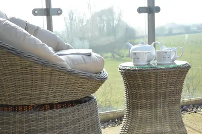 two wicker baskets with mugs sitting on them in a window at King George Penthouse in Aldeburgh