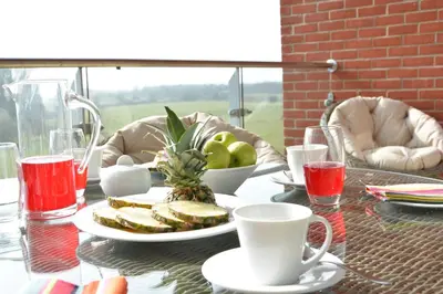 a table with a plate of sandwiches and a bowl of fruit at King George Penthouse in Aldeburgh