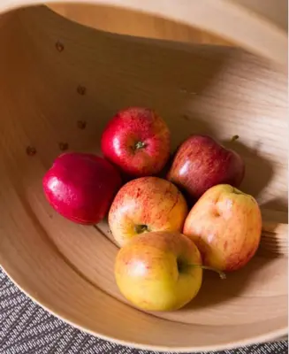 a bowl of apples and pomegranates on a table at Fullers Hill Cottages in Little Grandsen