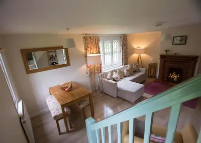a living room with a couch and a table at Fullers Hill Cottages in Little Grandsen