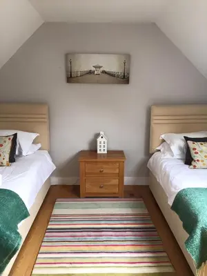 a bedroom with two beds and a wooden dresser at Fullers Hill Cottages in Little Grandsen